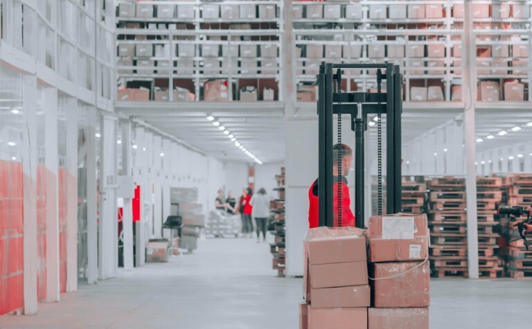 a worker operates a forklift in a data connected warehouse.